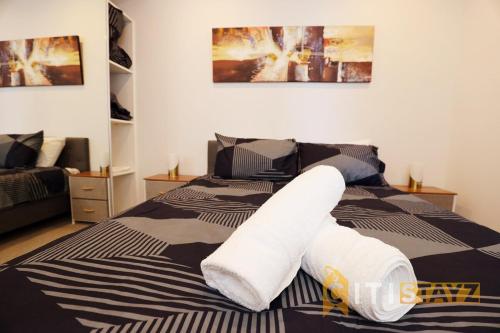 ein Bett mit weißen Handtüchern darüber in der Unterkunft Red Rose Retreat - 1bd 1bth 1CarSp Apt in Lyons