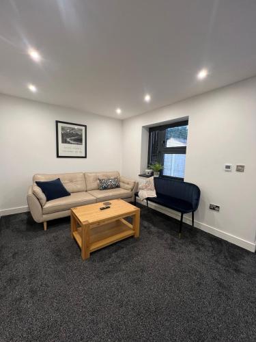 a living room with a couch and a coffee table at The Homely Retreat Spacious Ground Floor Flat Near Oxford City Centre, Free Parking in Oxford