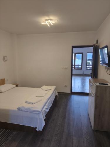 a bedroom with a bed and a door to a balcony at Vila Smeu in Dubova