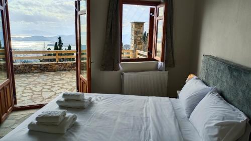 a bedroom with a bed with two towels on it at Aurora-Inn in Makrinítsa