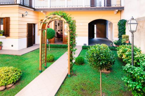 un giardino con un arco e erba verde di Il Giardinetto Rooms a Ferrara