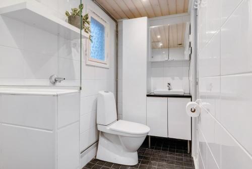 Un baño blanco con inodoro y lavabo. en Cozy Lapland Hideaway, 2BDR, Wifi & Parking, en Rovaniemi