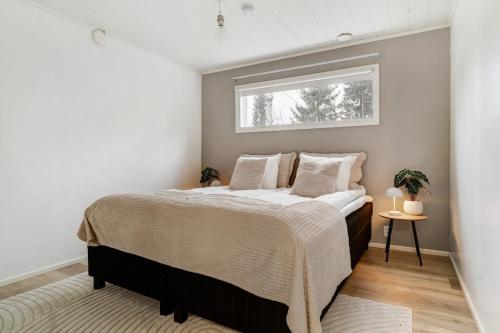 un dormitorio con una cama y una ventana en Cozy Lapland Hideaway, 2BDR, Wifi & Parking, en Rovaniemi