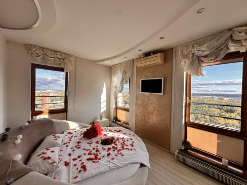 a bedroom with a bed with red flowers on it at Skyhouse Riga Relax Penthouse And Spa in Rīga