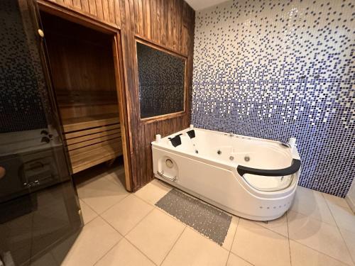 a bathroom with a bath tub in the corner at Skyhouse Riga Relax Penthouse And Spa in Rīga