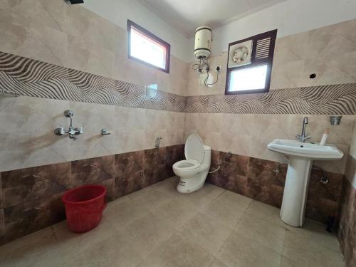 a bathroom with a toilet and a sink at Shree Dev Asthanam in Bhīm Tāl