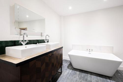 a bathroom with two sinks and a large mirror at The Loft - Luxe City Centre Penthouse Apartment in Norwich