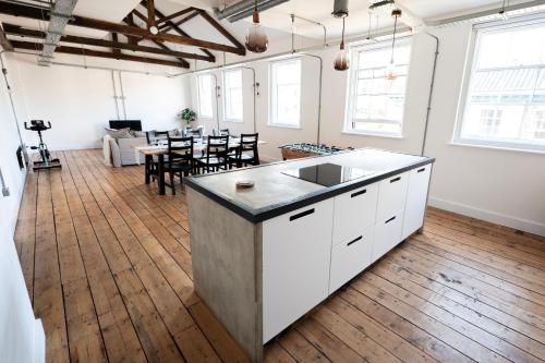 a kitchen with a sink and a living room at The Loft - Luxe City Centre Penthouse Apartment in Norwich