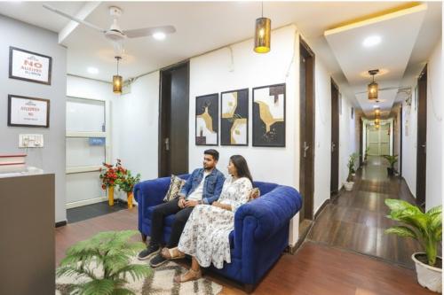 a man and woman sitting on a couch in a living room at FabExpress Shree Ram Aadhar 900 Mtr from Ram mandir in Ayodhya