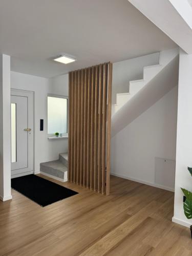 Una sala de estar vacía con una escalera con una cortina de madera. en Rednitz Luxus House, en Rednitzhembach