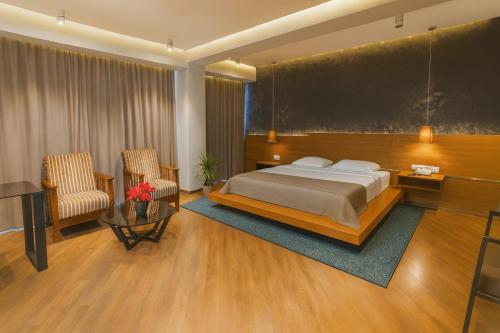 a hotel room with a bed and two chairs at Golden Palace Hotel in Tbilisi City