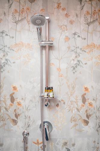 a shower in a bathroom with floral wallpaper at Plebiscito Luxury Rooms in Naples