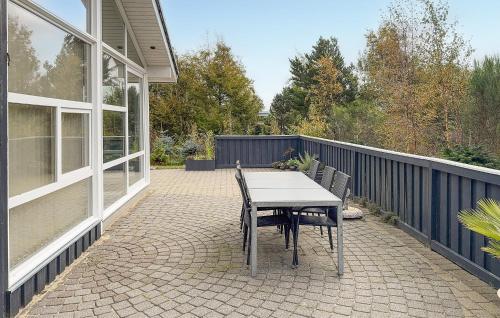 a table and chairs on the patio of a house at Cozy Home In Tarm With Sauna in Højsand