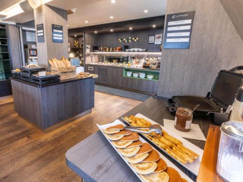 ドーヴィルにあるNovotel Deauville Plageのテーブルの上にパンとペストリーのトレイが置かれたパン屋