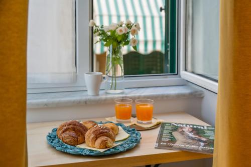 ナポリにあるPlebiscito Luxury Roomsのテーブル(ペストリープレート1皿、オレンジジュース2杯付)