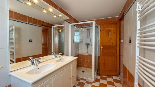 a bathroom with two sinks and a shower at Villa avec piscine à deux pas des pistes cyclables in Rivedoux-Plage