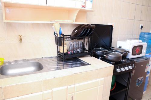 a kitchen counter with a sink and a stove at Solace Park Apartments in Gatunga