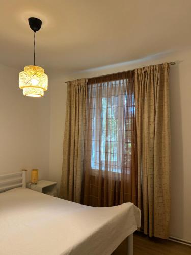 a bedroom with a bed and a window with curtains at Stela's Home in Ploieşti