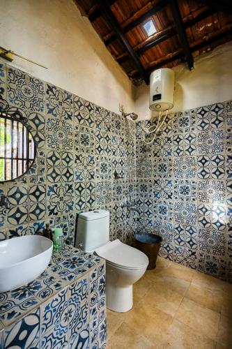 a bathroom with a toilet and a sink and a mirror at Jade Hills Coorg in Madikeri