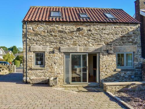a stone building with a window and a bench in front at The Barn in Old Brampton