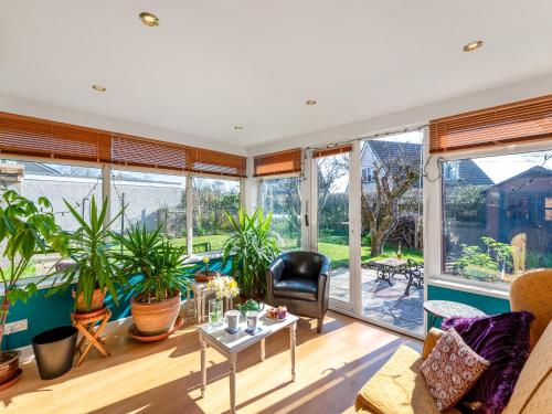 a living room with large windows and plants at Applepips in Stirling