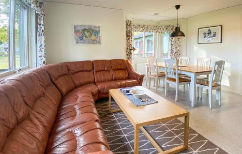 a living room with a brown leather couch and a table at 2 Bedroom Nice Home In Byxelkrok in Byxelkrok