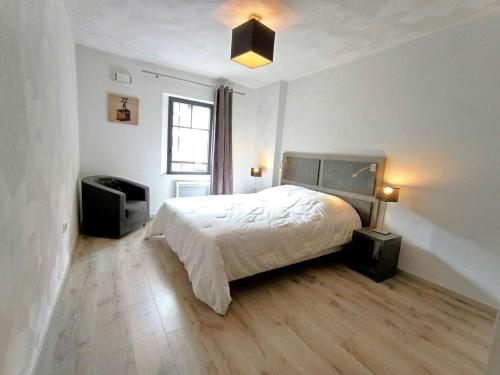 une chambre blanche avec un lit et une télévision dans l'établissement Confort et Bien-être à Saint-Lary-Soulan - T3 pour 6 avec WiFi et Parking - FR-1-457-383, à Saint-Lary-Soulan