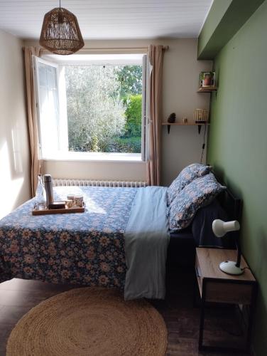 a bedroom with a bed and a window at À fleur de source in Mer
