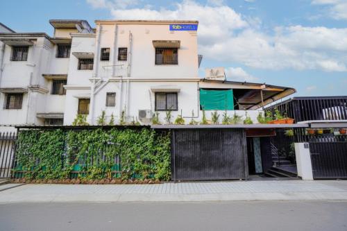 ein weißes Gebäude mit einem Zaun davor in der Unterkunft FabHotel Viva House - Talegaon in Pune