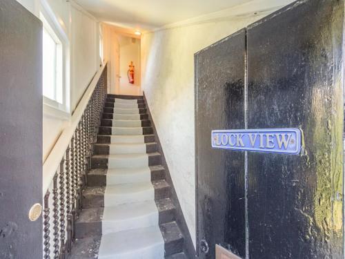 a staircase with a blue sign on the wall at Lockview Upper Flat in Fort Augustus