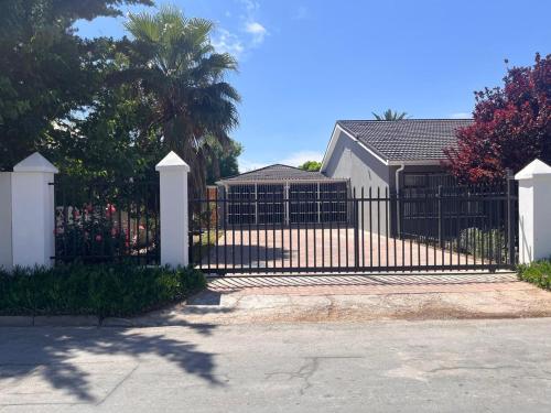 a black fence with a white gate in front of a house at Riverside in Beaufort West