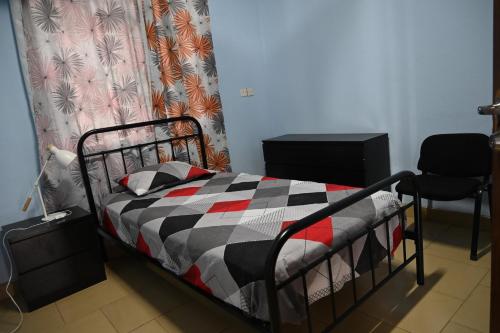 a bedroom with a bed with a checkered blanket at The Accra Backpackers Hostel in Accra