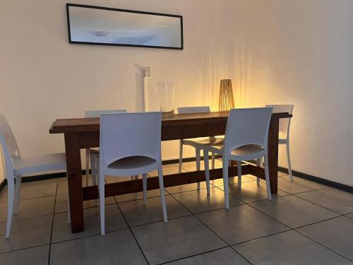 a dining room table with white chairs and a wooden table at Riverside in Beaufort West