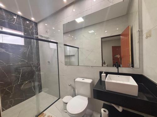 a bathroom with a toilet and a sink and a shower at Pousada Lua Bela in Piranhas
