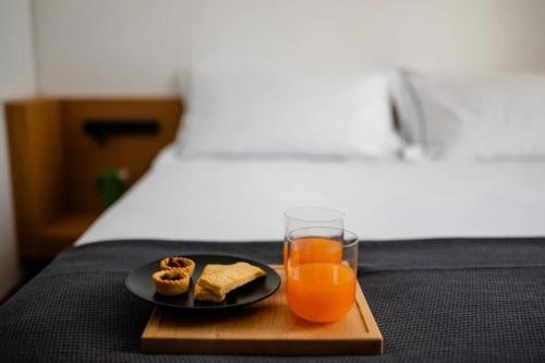 a tray with a plate of food and two glasses of orange juice at Arringo - Stay comfy in Conversano