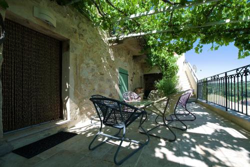 a patio with two chairs and a table on a building at La Maison du Passage - Chambres - Suites premium, Spa, Piscine et Restaurant in Martignargues