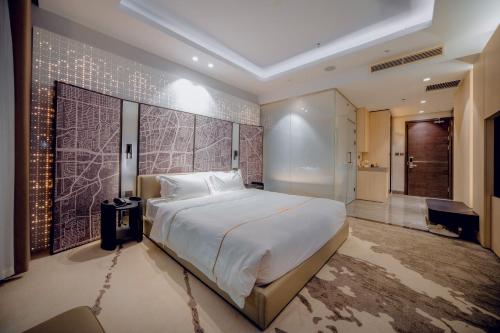 a bedroom with a large bed and a walk in shower at X-Digital HOTEL in Bắc Ninh