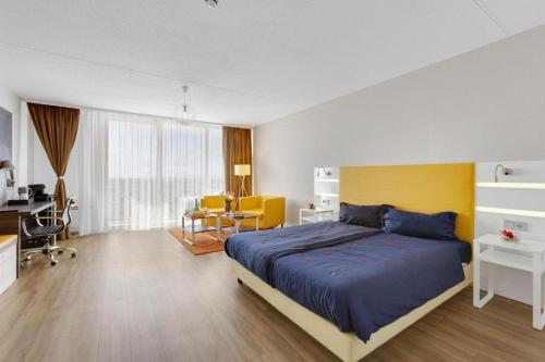 une chambre avec un grand lit et un bureau dans l'établissement Hotel Montago- 40qm große und günstige Appartements für Langzeitaufenthalte, à Neu-Isenburg