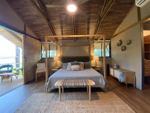 ein Schlafzimmer mit einem Himmelbett und einem Teppich in der Unterkunft Premium Lakefront Cabin 3 The Firefly in Bastrop