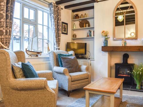 a living room with two chairs and a fireplace at Sea Dog Cottage - Uk42479 in Whitby