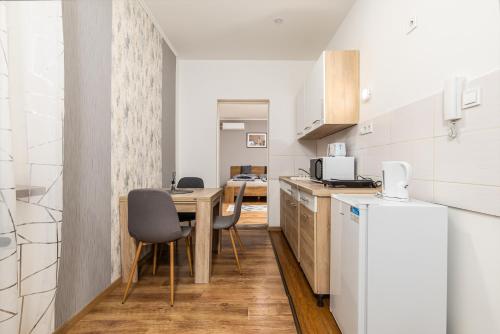 a kitchen with a table and chairs and a refrigerator at Mira Nest - Budapest City in Budapest