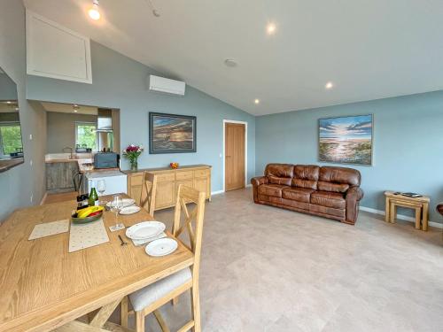 Una cocina y una sala de estar con una mesa y un sofá. en Grey Rocks Apartment, en Kippford