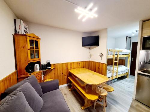 a living room with a couch and a table at Appartement au rez chaussée au pied des piste de ski in Bellevaux