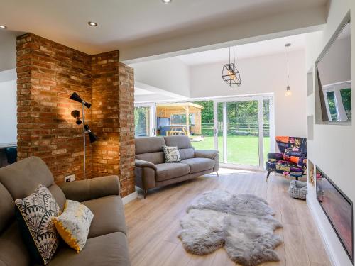 a living room with a couch and a brick wall at Sea Breezes in Anderby