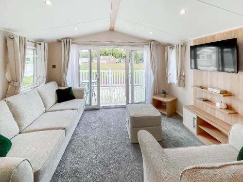 a living room with a couch and a tv at The Manor Retreat in Banchory