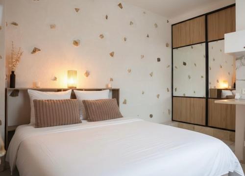 ein Schlafzimmer mit einem großen weißen Bett mit zwei Kissen in der Unterkunft Maison 4 pers 10 min Disneyland Paris Terrasse Parking Gratuit in Chalifert