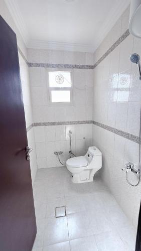 a bathroom with a toilet and a window at شقق زهرة النزلاء المخدومة in Buraydah