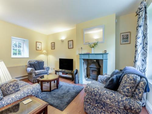 a living room with two couches and a fireplace at Primula House in Sticklepath