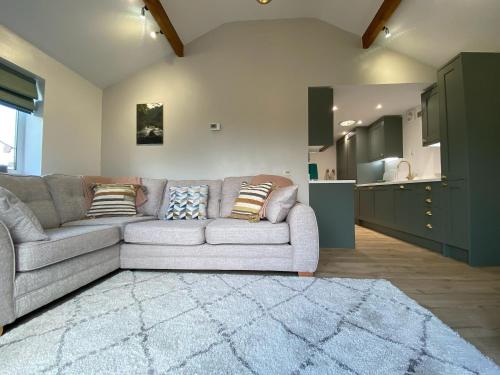 a living room with a couch and a kitchen at Oakleigh in Old Brampton