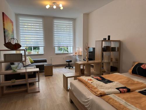 a bedroom with a bed and a living room at Appartement Chemnitz-Kaßberg in Chemnitz